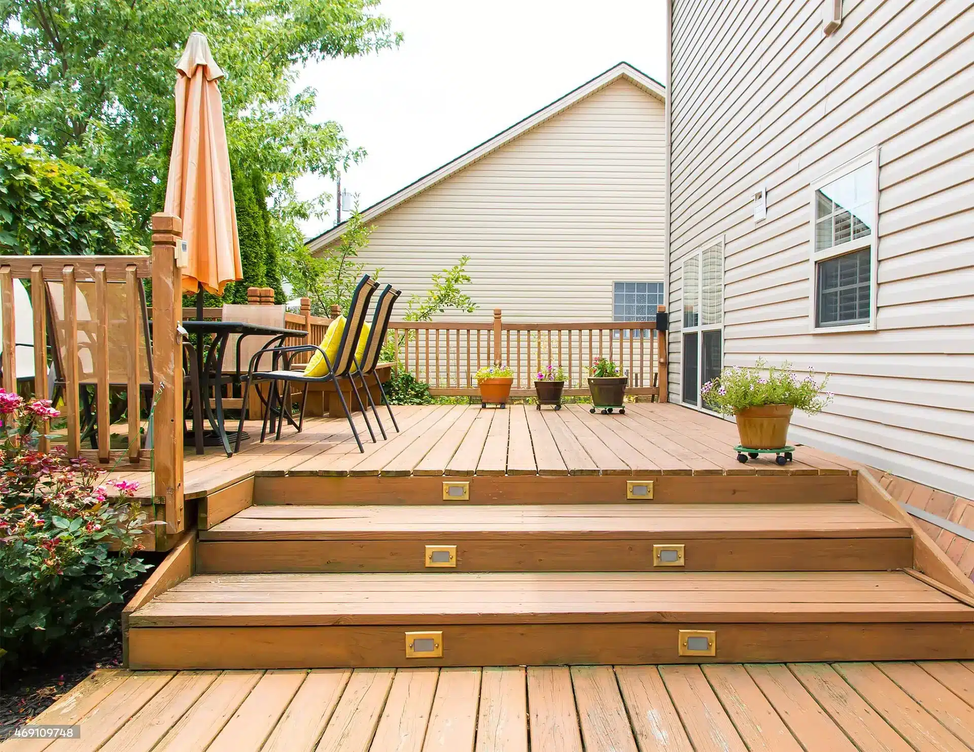 backyard-custom-deck-with-stair-lights-and-outdoor-living-dining-set-area-with-beautiful-potted-plants-in-mansfield-tx